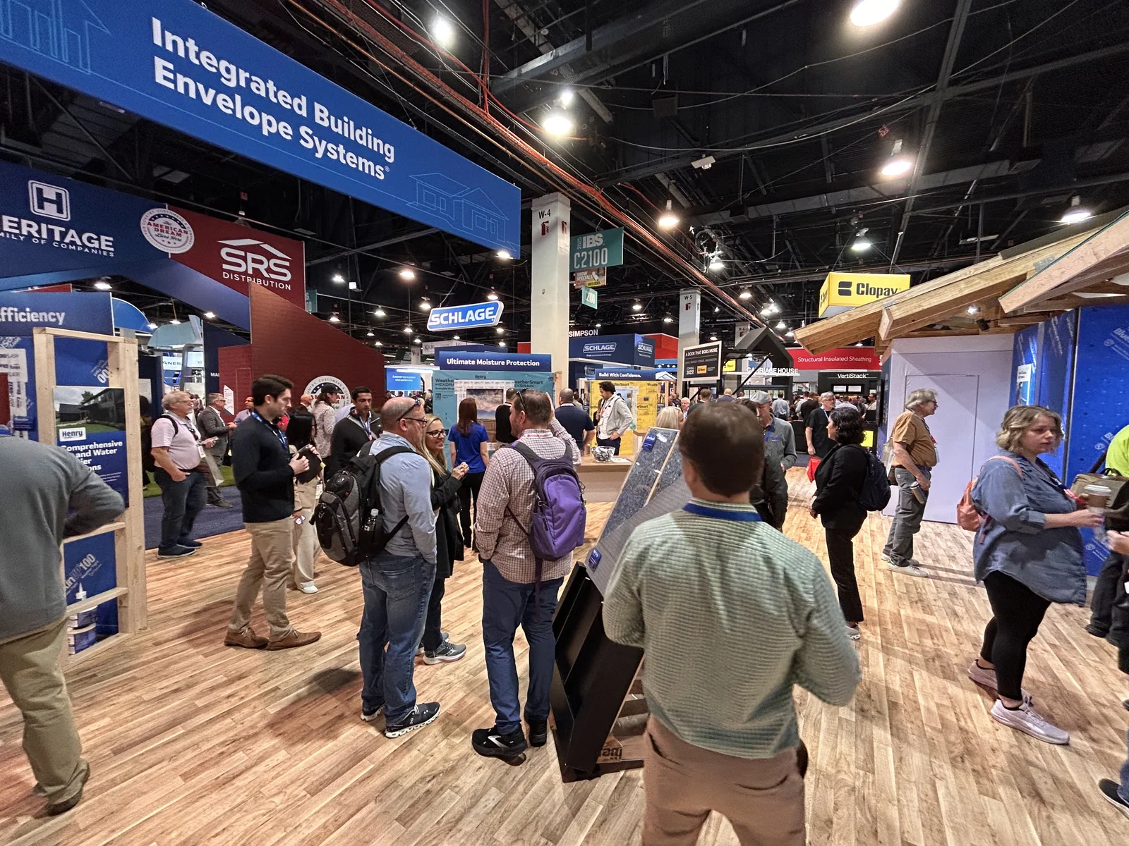 Builders crowd the aisle under the Integrated Building Envelope Systems sign